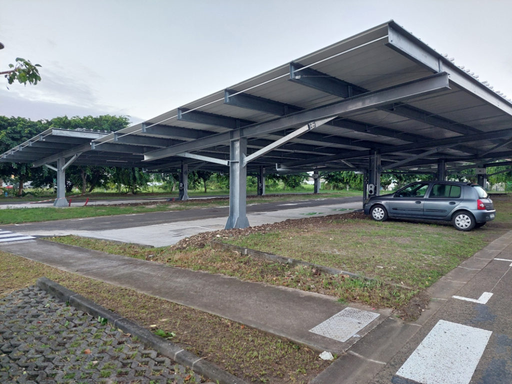 Ombrières photovoltaïques en autoconsommation totale associées à une infrastructure de recharge de véhicules électriques.